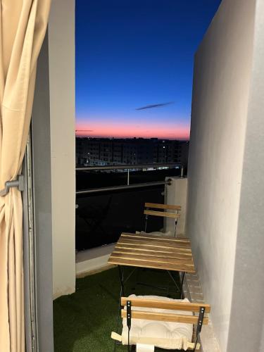 a table and bench on a balcony with a view at Appartement en bord de mer idéal pour les vacances in Imi Ouaddar