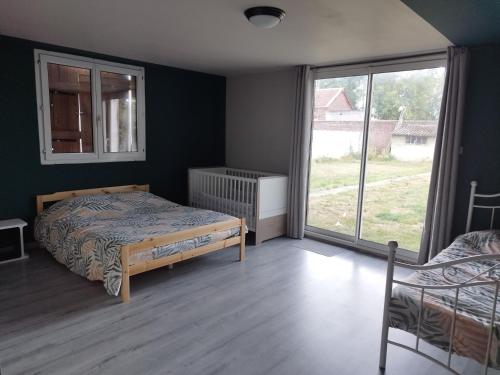 a bedroom with a bed and a large window at Parfaite pour toutes direction in Fenain