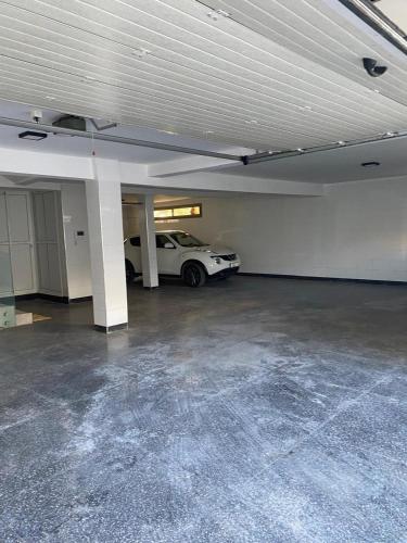 a garage with a white car parked in it at Villa avec piscine Mohammedia in Mohammedia
