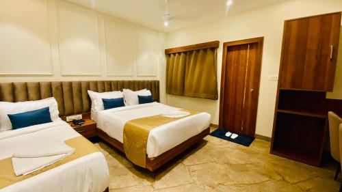 a hotel room with two beds and a window at The Velar Hotel, Vijay Nagar in Indore