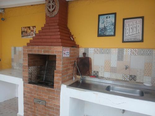 Casa com piscina praia grande Beach House في برايا جراندي: مطبخ مع موقد من الطوب مع موقد