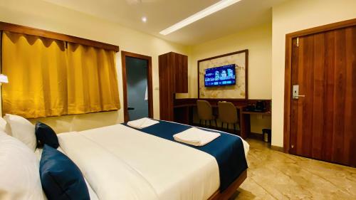 a hotel room with a large bed and a desk at The Velar Hotel, Vijay Nagar in Indore