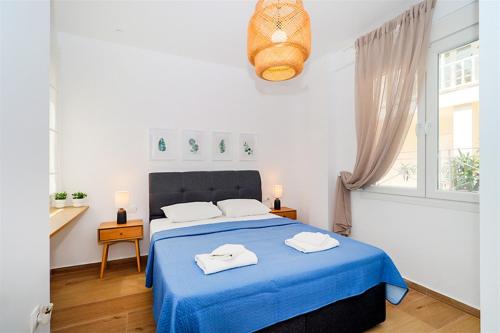 una camera da letto con un letto blu con due asciugamani sopra di Pefka House Hanioti 6 guests 2 bedrooms a Hanioti