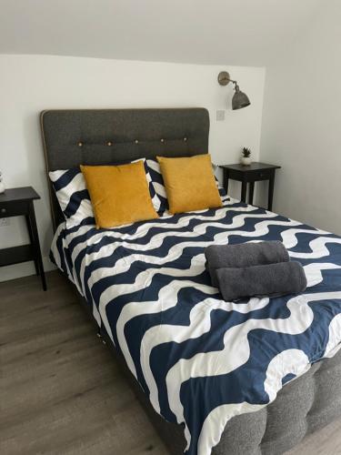 a bed with black and white sheets and pillows at 1 Bed Room Flat with sofa Bed, full kitchen in Weston-super-Mare