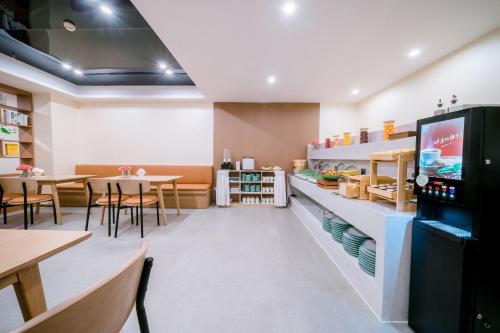 a restaurant with tables and chairs and a television at Argyle WAIFIDEN Baolidian Hotel -Free shuttle bus during Canton Fair in Guangzhou