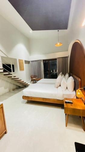 a bedroom with a large bed with a wooden headboard at Red River Retreat in Hatikhuli
