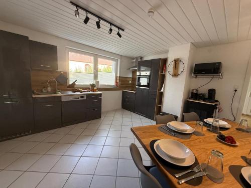 a kitchen with a wooden table and a dining room at Großzügige Ferienwohnung in Fleischwangen - Platz bis zu 8 Personen in Fleischwangen