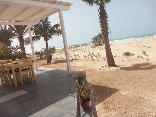 a patio with a table and chairs on the beach at Vilas Praia de Chaves Deluxe house sol y mar in Rabil