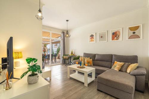 a living room with a couch and a table at Holiday Valley Harmony Bungalow in Adeje