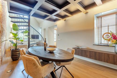 a dining room with a wooden table and chairs at Exclusieve luxe B&B Het Renteniershuis in Molenaarsgraaf