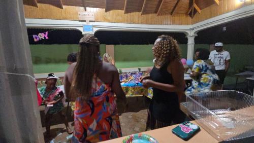 two women standing in a room with a party at Eve's Rockaway Villa in Alligator Pond Village