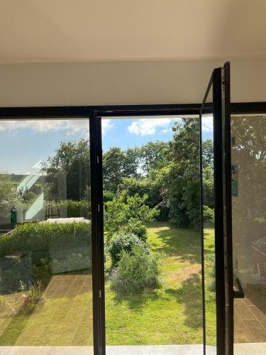 an open sliding glass door looking out at a garden at Rose et violette in Brélès