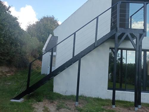 a building with a staircase on the side of it at Rose et violette in Brélès