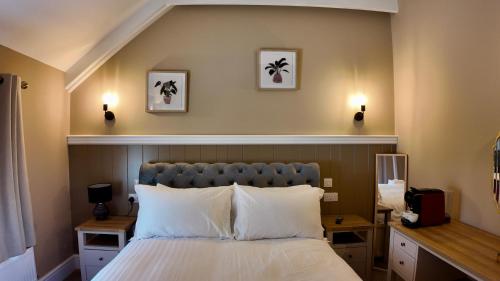a bedroom with a bed and two lights on the wall at Kil Margh - Rising Sun Inn in Altarnun