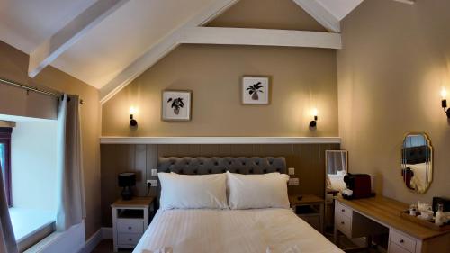 a bedroom with a bed and a desk and a window at Kil Margh - Rising Sun Inn in Altarnun