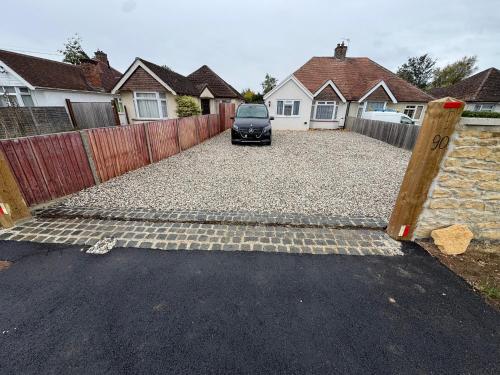 a car parked in a driveway with a fence at Bota Bungalow, Kidlington,Oxford in Kidlington