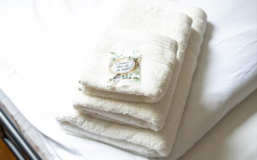 four towels are stacked on a bed at Central Living Apartments in Linz