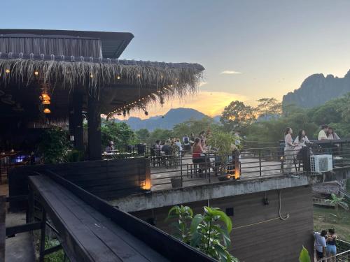 ヴァンヴィエンにあるBan Laos Guesthouseのレストランの席に座る人々