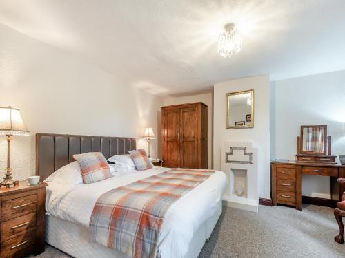 a bedroom with a bed and a dresser and a mirror at Halls Bank Farm in Aspatria