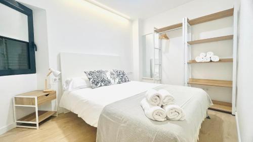a bedroom with a bed with towels on it at Bajos con encanto by Prestigi in Terrassa