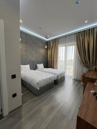 a bedroom with two beds and a large window at AS Hotel Ganja in Ganja