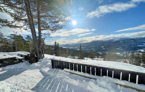 a bench covered in snow with the sun in the background at 5 Bedroom Stunning Home In Eggedal in Eggedal