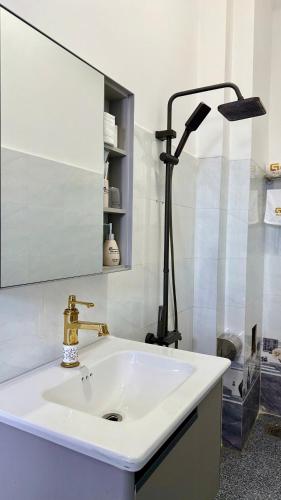 a white bathroom with a sink and a lamp at Gành Đá Đĩa Retreat Hotel in Tuy An