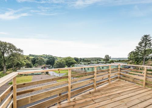 a wooden deck with a view of a parking lot at Kippford View Holiday Park in Castle Douglas