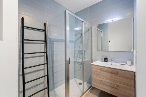a bathroom with a glass shower and a sink at Le Cocon du Leman in Thonon-les-Bains