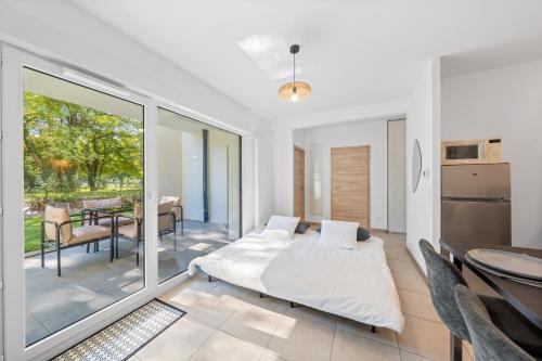 a bedroom with a bed and a balcony with a table at Le Cocon du Leman in Thonon-les-Bains