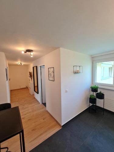 a living room with white walls and wooden floors at Zentrumsnah und modern mit Seeblick in Weggis in Weggis