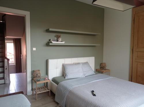 a bedroom with a bed with a white headboard at B&B Emma in Bruges