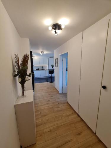 a hallway with a room with white walls and a table at Zentrumsnah und modern mit Seeblick in Weggis in Weggis