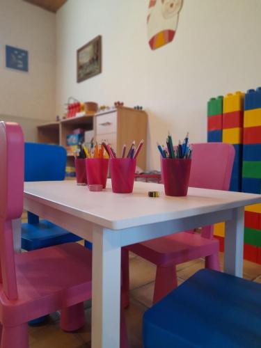 a table with colorful chairs and pens at Ferienhof Rüßmann in Lennestadt