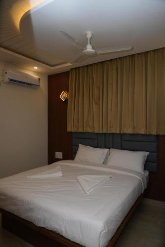 a bedroom with a large white bed with a ceiling at SN Comforts in Bengaluru