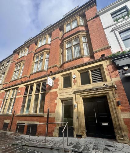 an old brick building with two doors on a street at Fenwick Street Hotel by EPIC in Liverpool