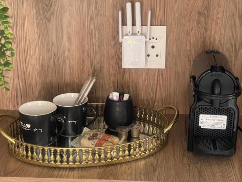 a tray with cups and a coffee maker and a clock at Stylish OceanBreeze 50 Central Mossel Bay in Mossel Bay