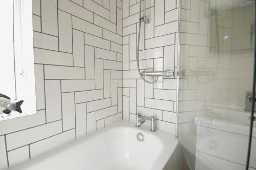 ソルカムにあるRefurbished Salcombe Townhouse Pet-Friendly with Garden, 2 Car Spaces, 3 Bedrooms, 2 Bathrooms, Countryside Views and close to North Sands Beachのシャワー、浴槽、洗面台を備えたバスルーム