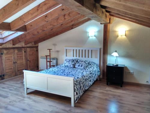 une chambre avec un lit dans une pièce avec des plafonds en bois dans l'établissement Molino de las Pontezuelas, à Piedrahíta