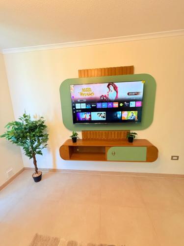 a flat screen tv on a wall in a living room at Departamento con piscina a pasos de la playa en La Serena in La Serena