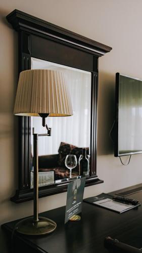 a lamp sitting on a desk with a window at Hotel Wileński in Olsztyn