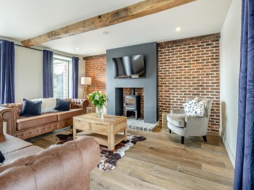 una sala de estar con una pared de ladrillo en The Dairy - Uk44130, en Baystonhill