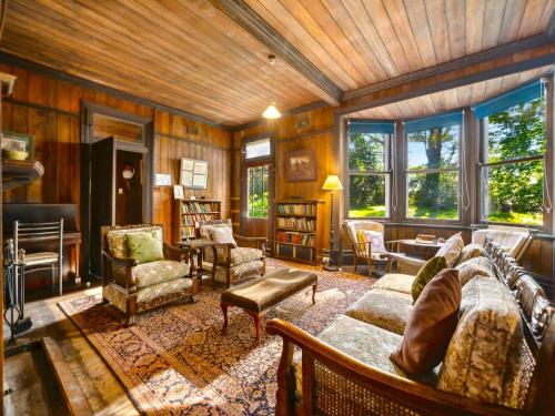a living room with a couch and chairs and windows at Rostherne House in Blackheath