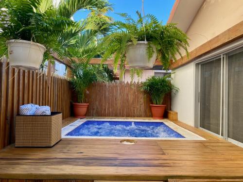 a swimming pool in a backyard with potted plants at Villas Princesa Beach Apartments in Punta Cana