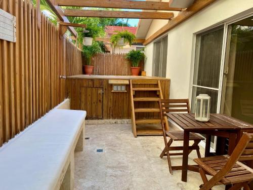 a patio with a table and chairs and a table and a bench at Villas Princesa Beach Apartments in Punta Cana