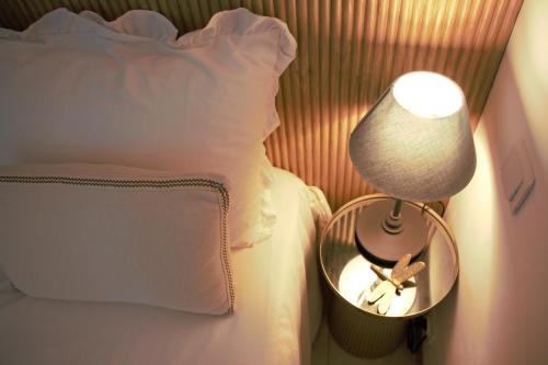 a lamp on a table next to a bed at Eden Palladio Appt 2 ch front de mer accès direct à la plage in Saint-Raphaël