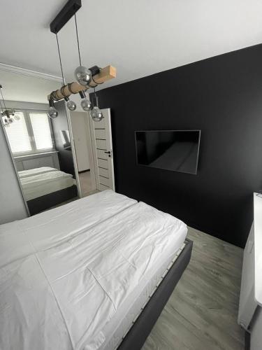 a bedroom with a white bed and a mirror at 3 Rooms Apartment in Gdańsk