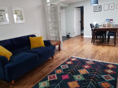 a living room with a blue couch and a table at Institution Road in Elgin