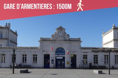 a large white building with a clock tower at Le Cinema - Les Demeures d'Adrien in Armentières