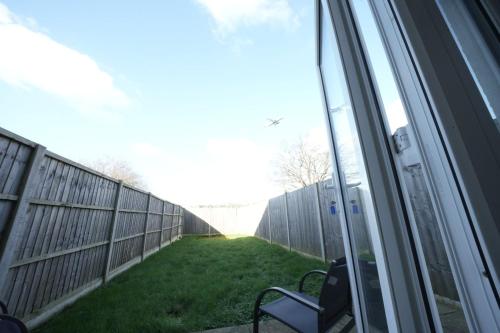 a view of a fence from a window of a yard at Hatton apartments HEATHROW AIRPORT- FREE parking-Free underground to and from Heathrow Airport Hatton Cross SEE picture-SEE LONDON fast Hatton cross to central London 30min in London